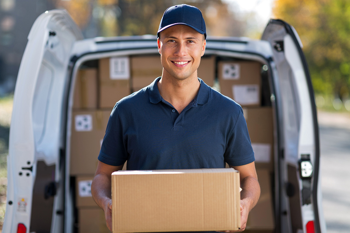 Delivery man standing in front of his van