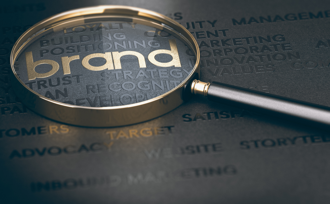 Brand marketing and management, branding or rebranding concept. 3d illustration of a magnifying glass over golden and black words.